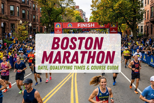 Boston Marathon runners racing through a city street toward the finish line with cheering crowds and autumn trees.